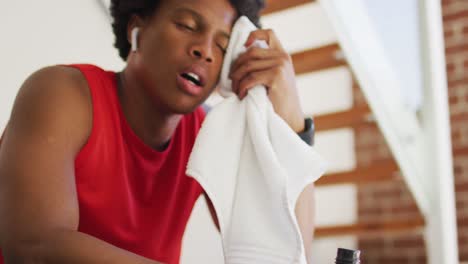 hombre afroamericano en forma haciendo ejercicio en casa y descansando cansado en casa