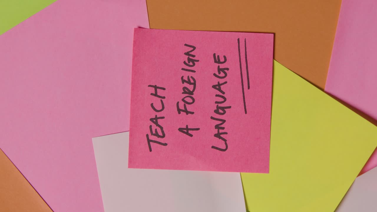 concepto educativo de notas adhesivas giratorias con enseñar un idioma extranjero escrito en la nota superior