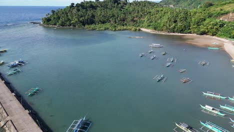 impresionante vista aérea de la idílica laguna tropical y el muelle con barcos de pesca tradicionales anclados y aguas marinas tranquilas, día soleado