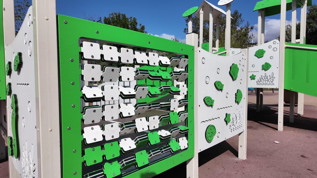 Pannello interattivo girevole verde e bianco in un parco giochi