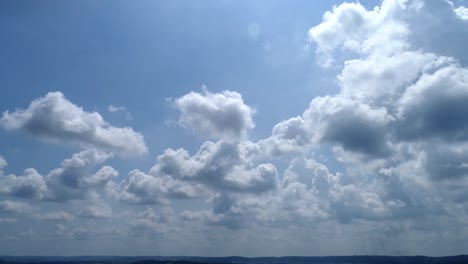 white fuffy clouds with blue sky seen left to right with slow zoom out