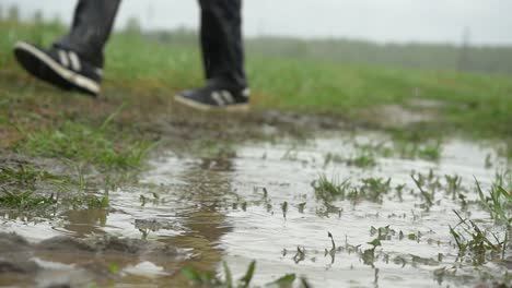 caminando por un campo fangoso bajo la lluvia