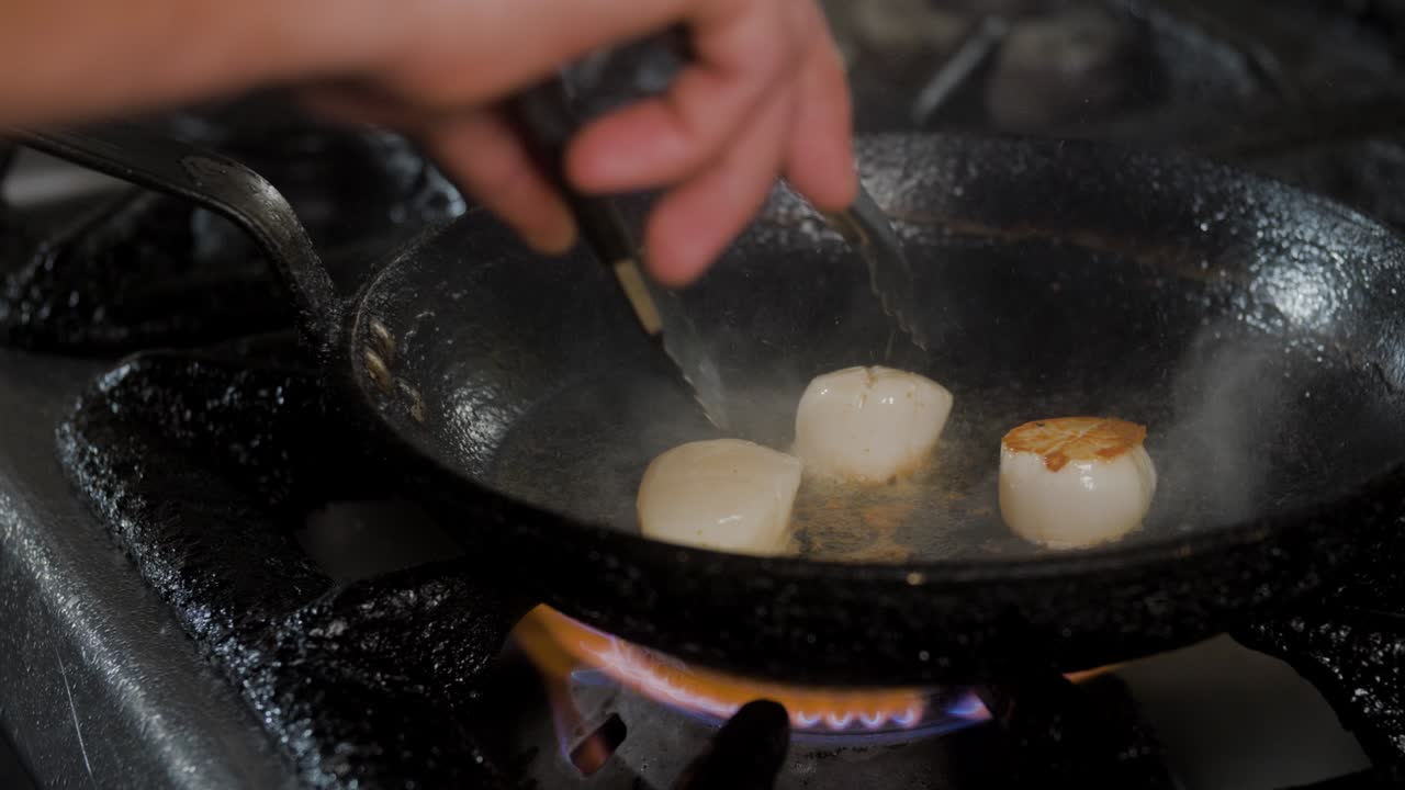 요리 팬에 가리비 요리 집게에 의해 회전