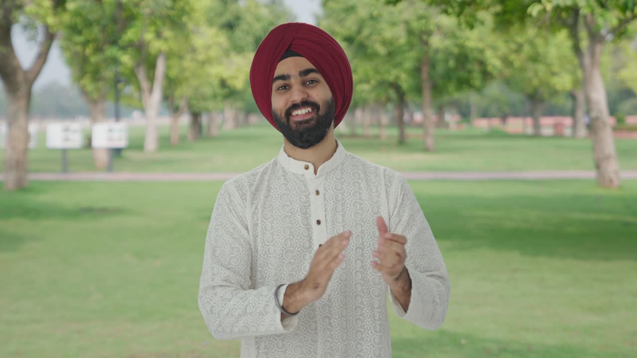 Uomo indiano Sikh che applaude e mostra apprezzamento in un parco
