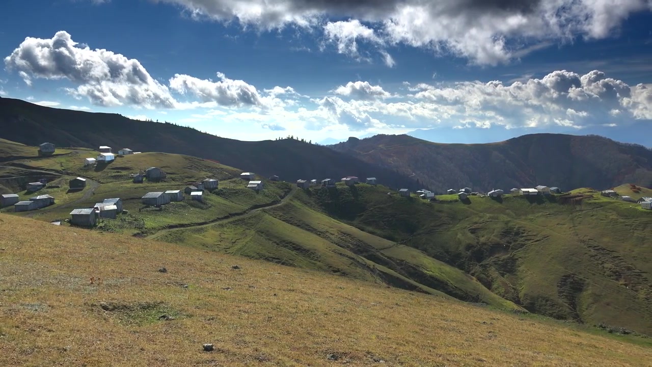 Piccolo villaggio di montagna adagiato su un crinale erboso