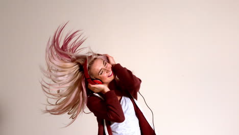 Sporty-blonde-listening-to-music-and-shaking-her-hair