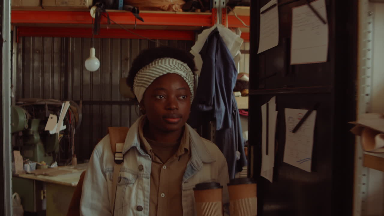 черная женщина приносит кофе и приветствует коллегу на работе