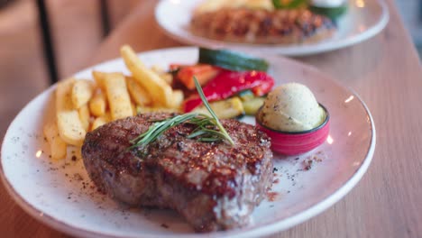 serving steak with fries and vegetable on a grill