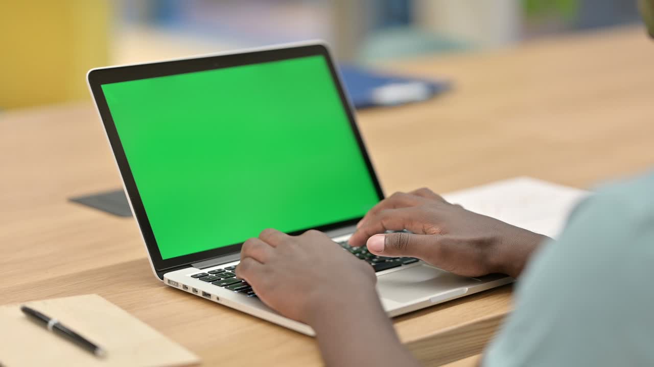 African Man Typing on Laptop with Chroma Screen