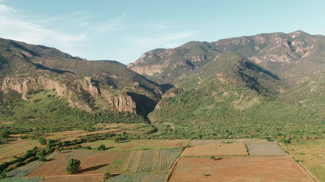 Canyon Garita con ripide scogliere rocciose, pendii montuosi verdi, vegetazione densa e campi agricoli coltivati vicino a Sierra Pénjamo, Guanajuato, Messico.