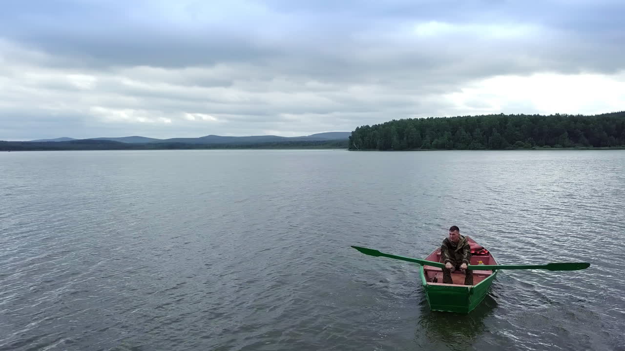 Man Rowing a Boat on a Lake