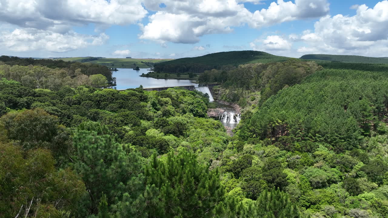 Aerial drone view of Divisa Dam in São Francisco de Paula, Brazil. Lush forest and calm reservoir waters. Ideal for nature, travel or environmental projects