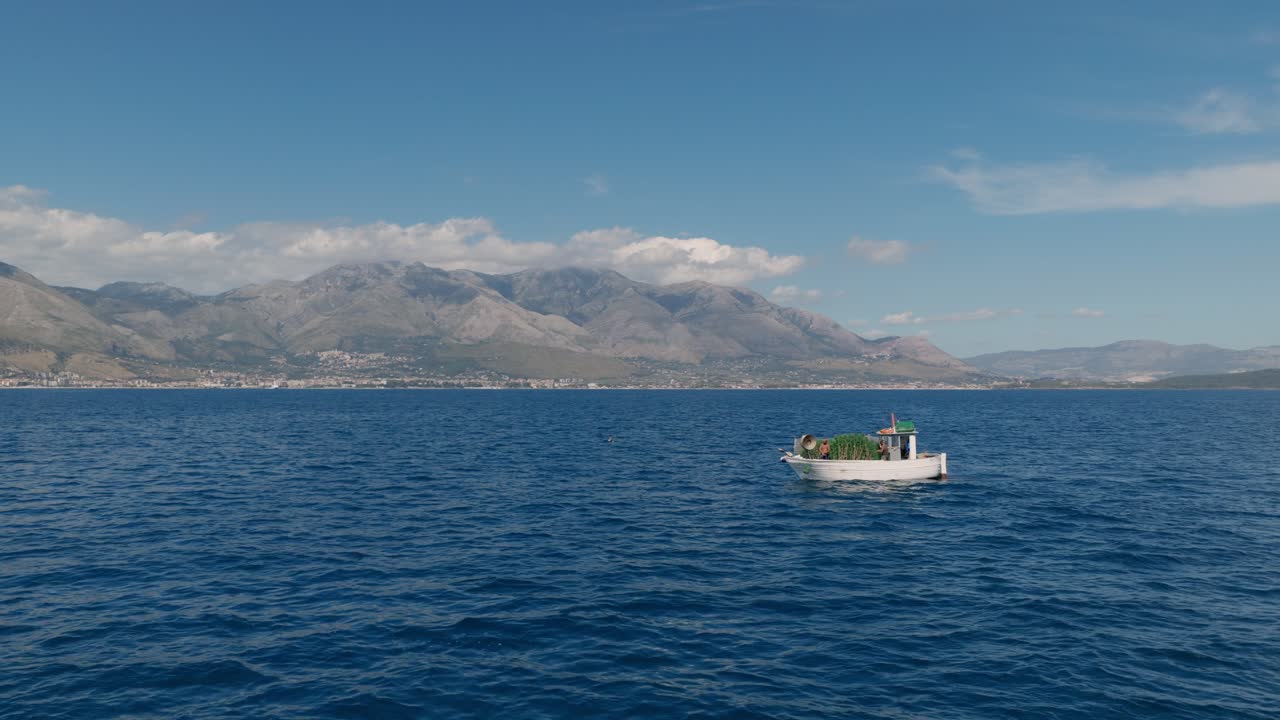 Pescadores en barco flotando en el mar azul en verano cerca de Gaeta, Italia. - Toma aérea.
