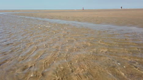 un arroyo de agua clara en la playa con arena blanca