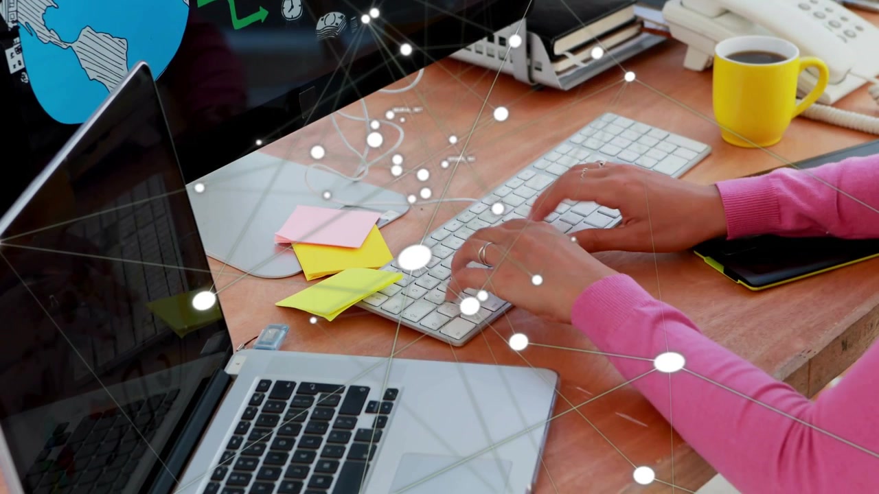 Adult woman typing and switching keyboards at desk, initiating tech network overlay on globe screen