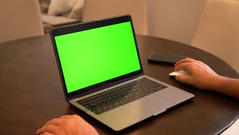 man using laptop with cellphone in background, green screen