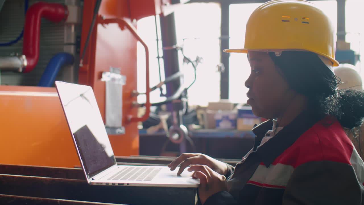 Female Factory Technician Working on Laptop