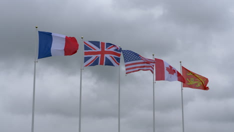 flags of different nations fluttering against cloudy sky