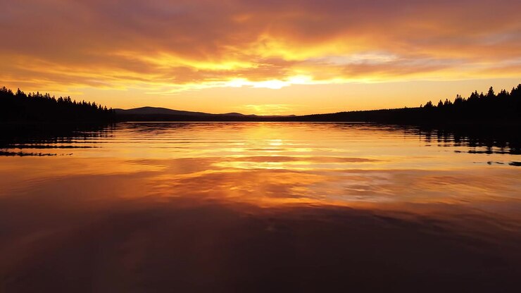 Golden sunset reflection over a calm lake at twilight