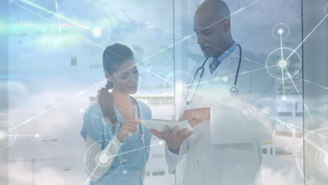 discussing patient data, doctors using tablet with animation of digital network overlay