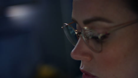 A-woman-computer-programmer-working-late-at-night-with-coding-reflections-in-her-glasses