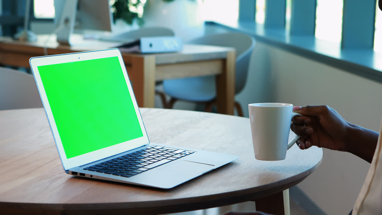 mujer ejecutiva usando una computadora portátil mientras toma café