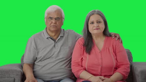 una pareja de ancianos indios frustrados mirando la pantalla verde de la cámara.