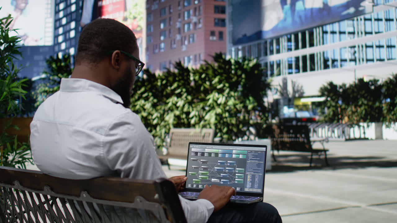African american male engaged in reading data analysis on laptop