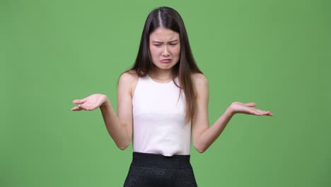 young beautiful asian businesswoman shrugging shoulders