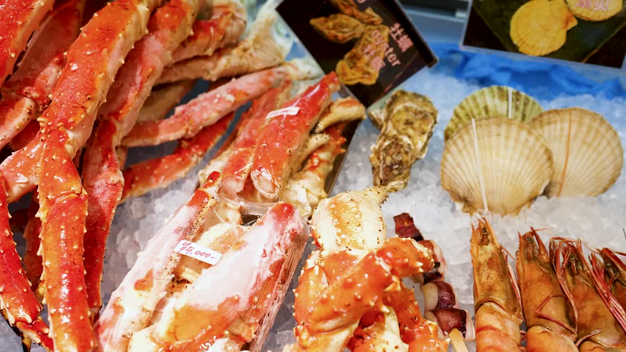 Uma panorâmica lenta da câmera revela patas de caranguejo-real, vieiras e camarão no gelo em Osaka.