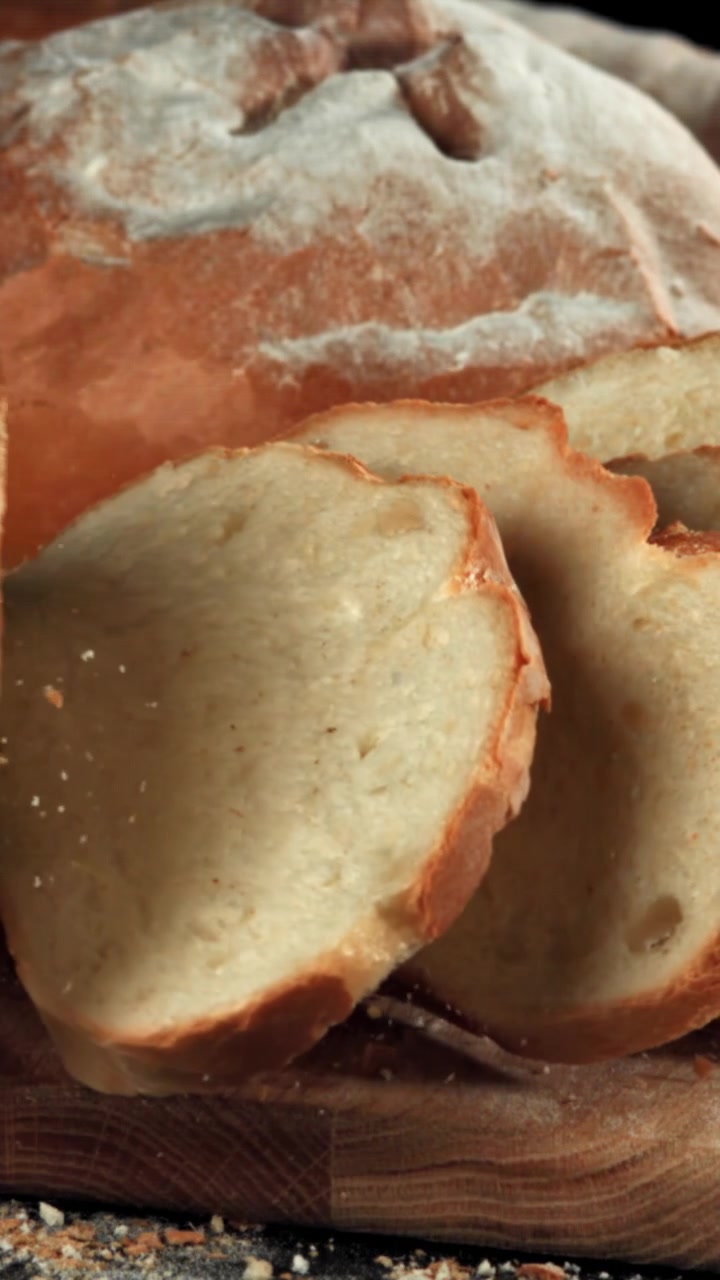 Pagnotta di pane appena affettata su un tagliere di legno rustico