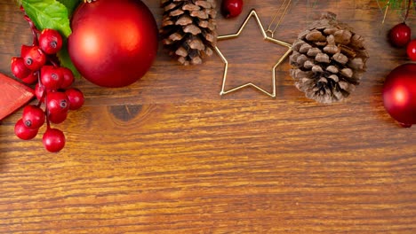 Composition-of-christmas-decorations-with-tree,-baubles-and-pine-cones-on-wooden-background