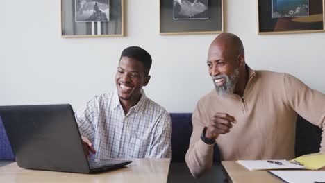 portrait of happy african american businessmen looking at camera at office