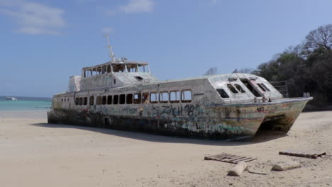 vista del barco de doble casco abandonado en la playa