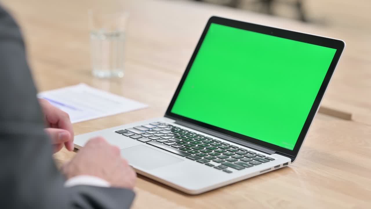 Rear View of Businessman looking at Laptop with Chroma Screen