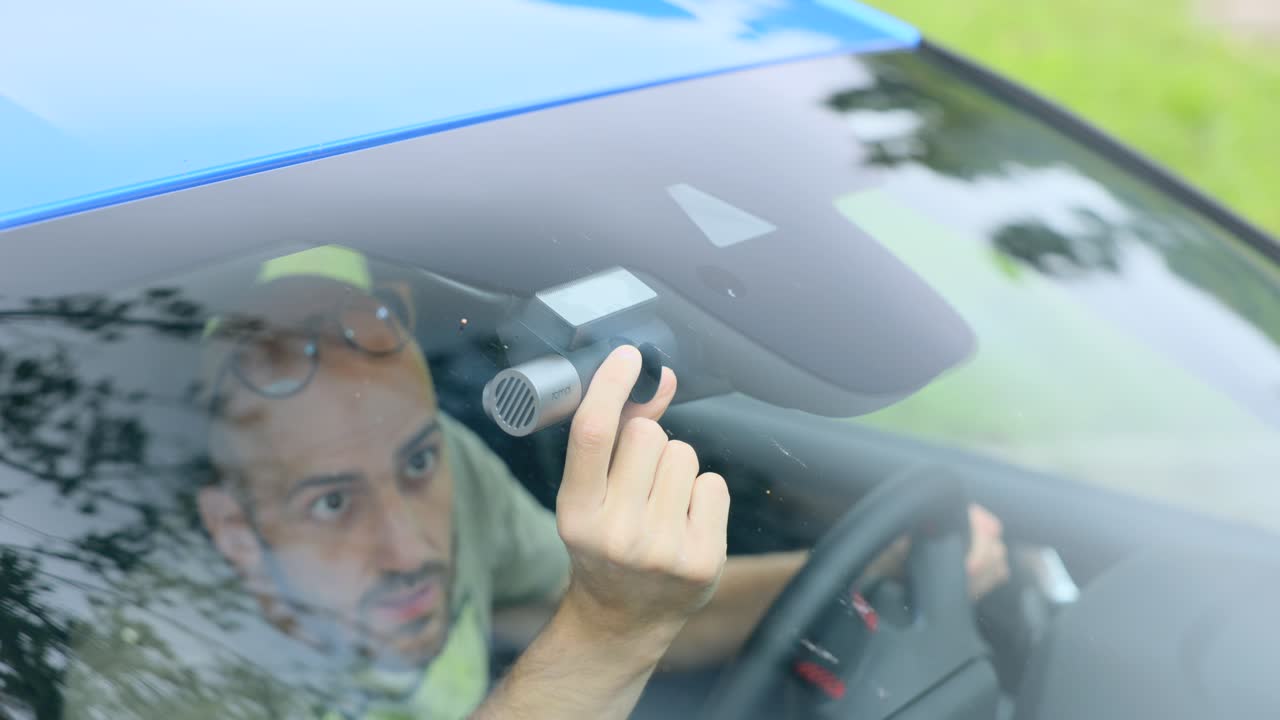 A Man Inside His Car Setting Up And Checking The Dash Camera. Close-up Shot