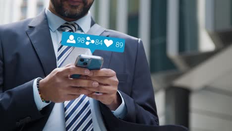 close up of businessman standing outside city offices looking at mobile phone with motion graphics showing multiple networking messaging and social media notifications