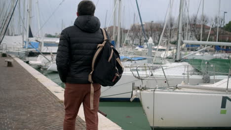 man walking along a dock at a harbor