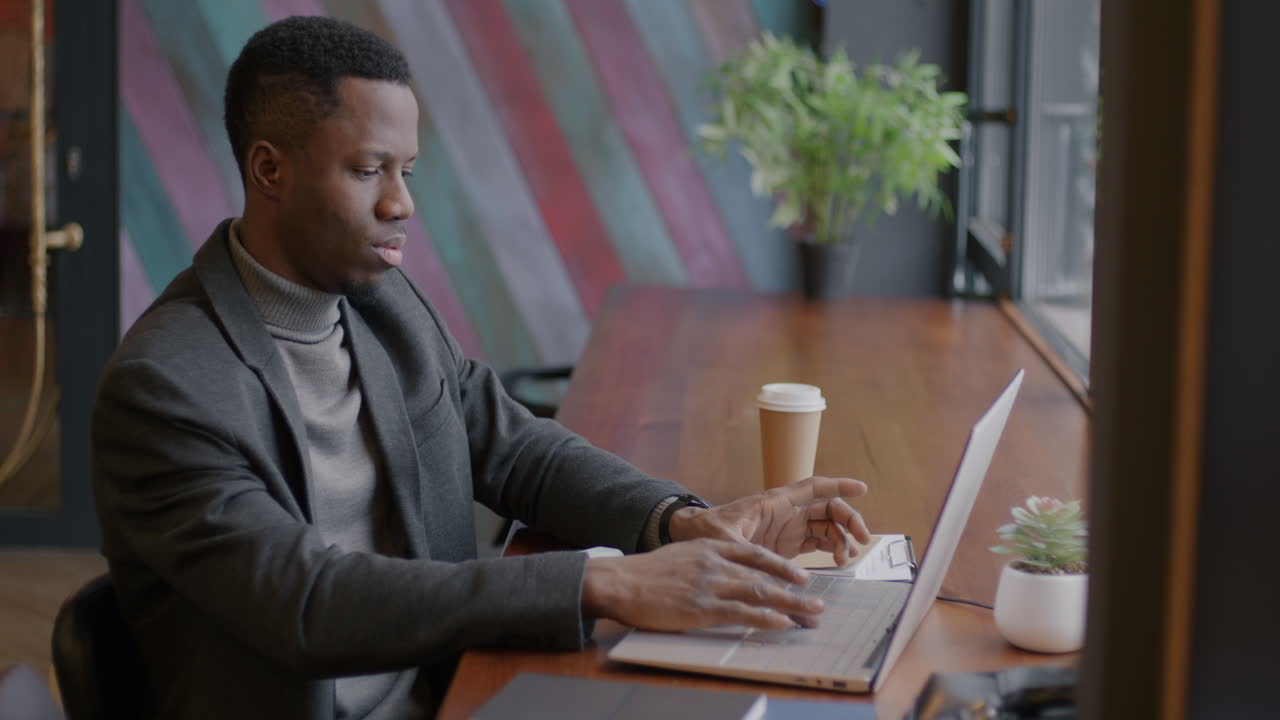 Man working on laptop in a cafe