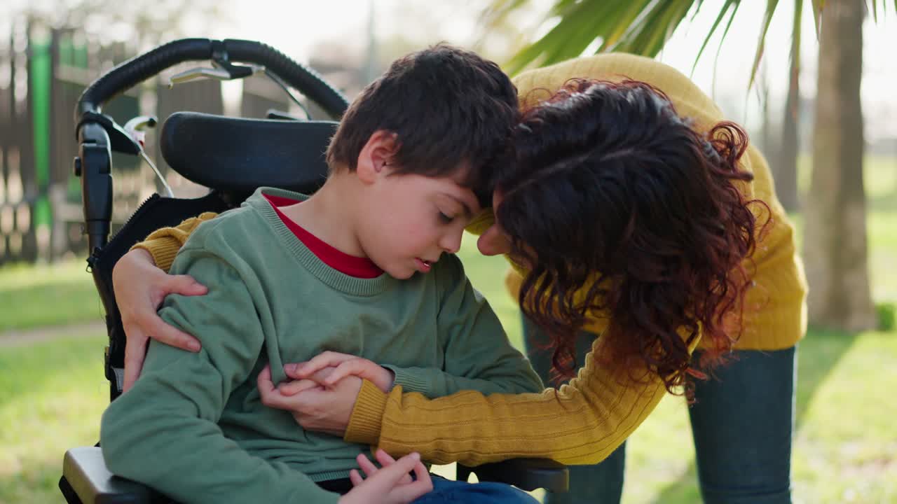A touching moment between a woman and a disabled boy in a wheelchair