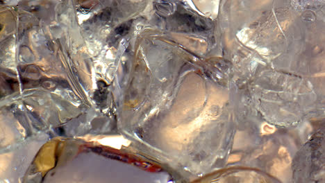 a glass full of ice cubes gradually being filled with lemonade