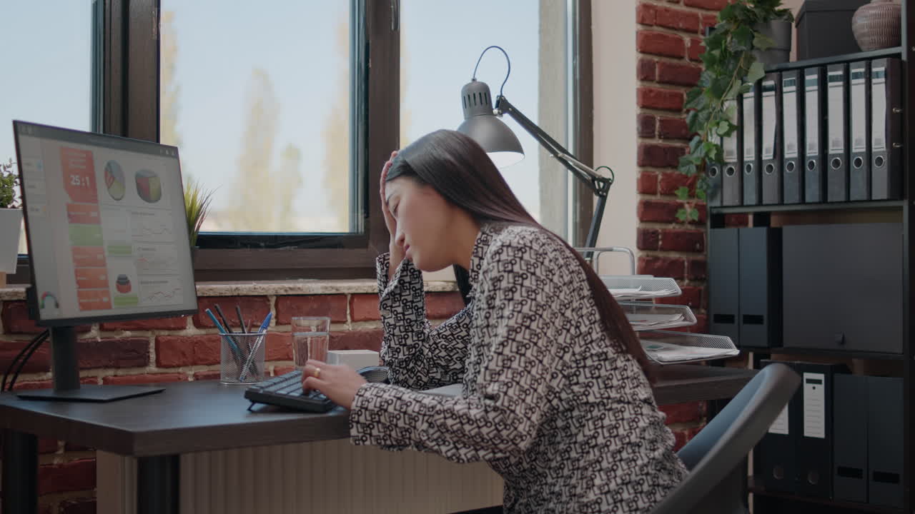 Employee dealing with headache while she works on project