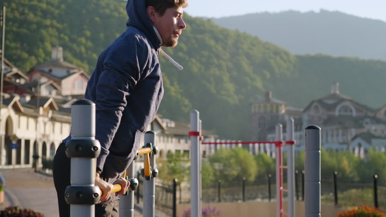 해가 뜨는 공원에서 풀업을 하는 남자