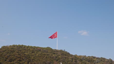 turkish red flag flies on top of hilltop on bosphorus scenic coastline