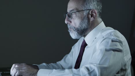 tired mature businessman using laptop