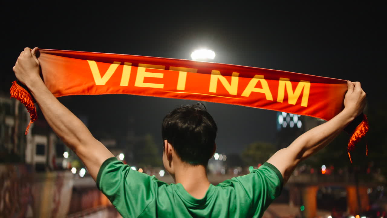 Cổ động viên Việt Nam ăn mừng với khăn quàng cổ