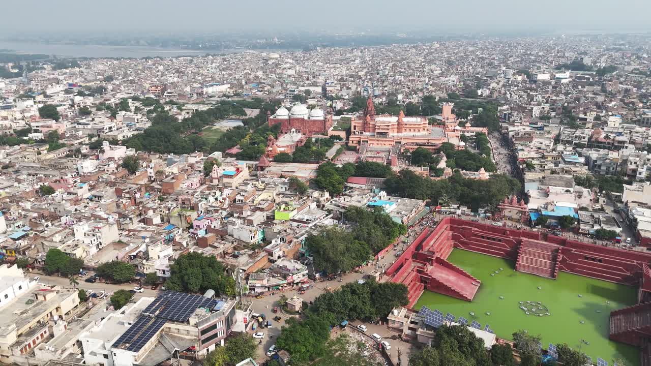 Vista aerea dei ghat di arenaria rossa di Shri Krishna Janm Bhumi e Potra Kund, circondati dal denso paesaggio urbano sacro e dai complessi templari di Mathura