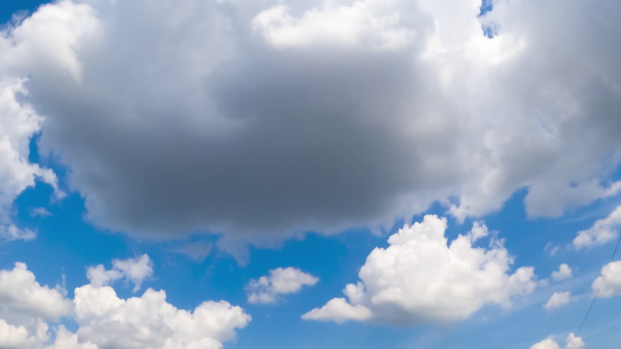 Beautiful soft clouds transforming in the atmosphere. Cumulus clouds are lit with bright summer sun. Low angle view. Timelapse.
