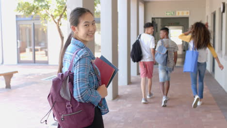 teenage asian girl smiles over her shoulder at high school
