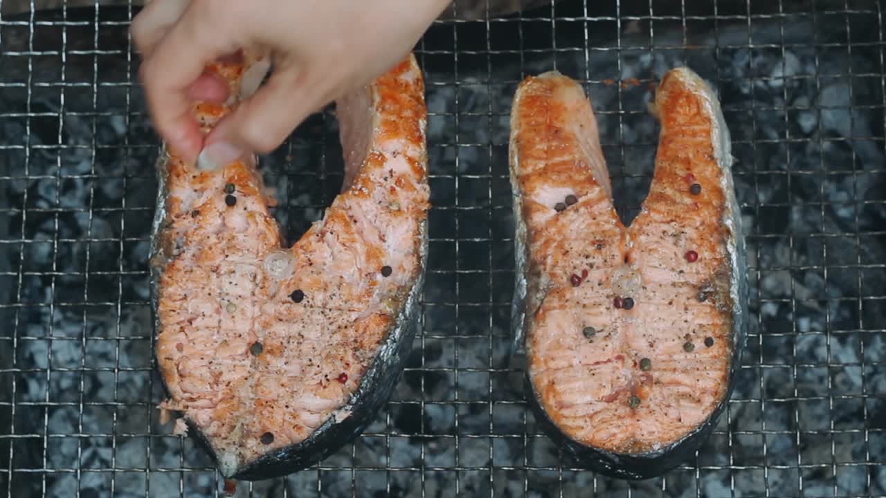 손으로 양념하는 연어 스테이크 검은 고추 콩. 연어 bbq 그릴